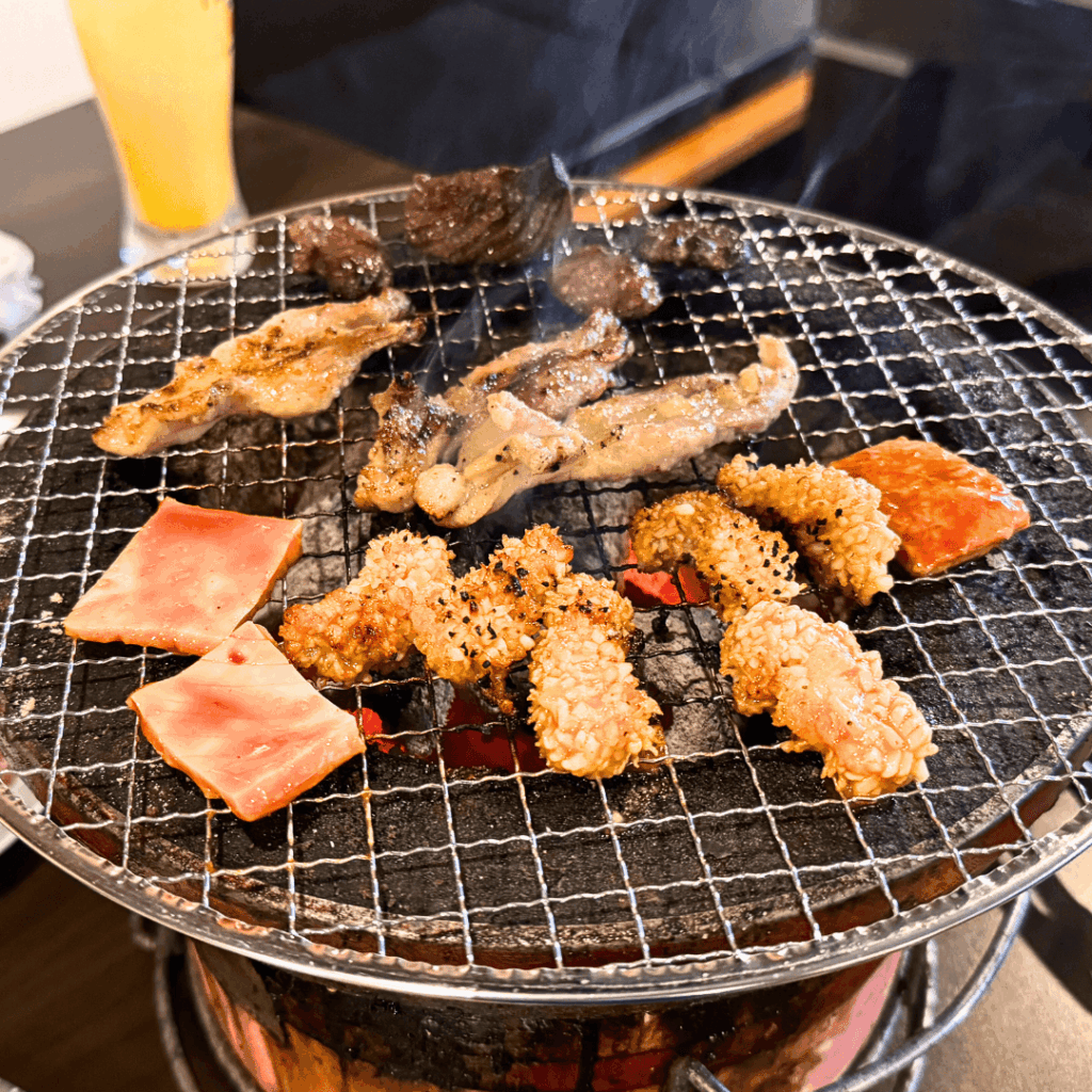 [画像：七輪の上のお肉たち]