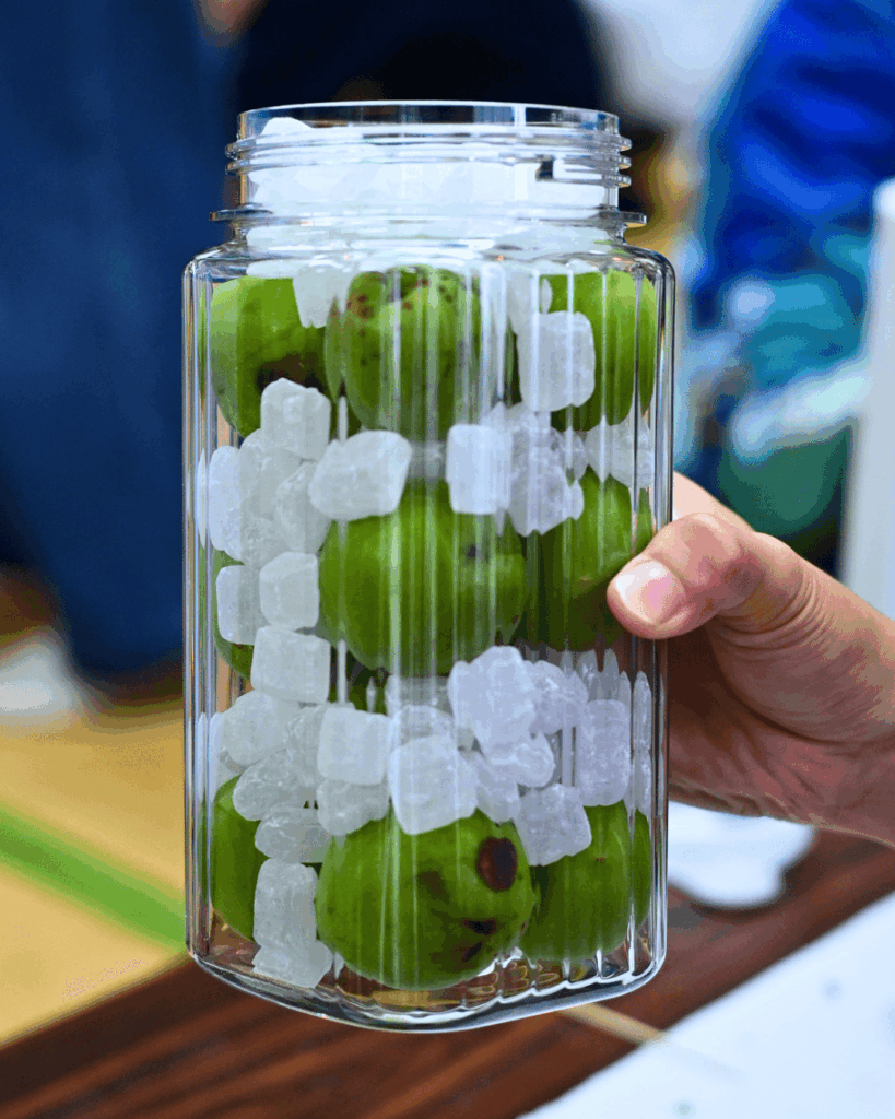 容器に梅の実と氷砂糖を交互に入れていく様子